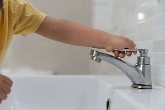 niño usando regadera de baño
